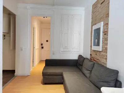 a living room with a couch and a brick wall at Family apartment Gracia in Barcelona