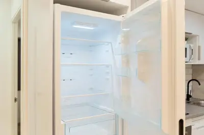 a white refrigerator with its door open in a kitchen at Refugio playero para 5 personas in Castelldefels