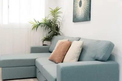 a blue couch with two pillows on it in a room at Refugio playero para 5 personas in Castelldefels