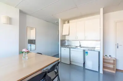 a kitchen with white cabinets and a wooden counter top at Residencia Universitaria Resa Lesseps in Barcelona