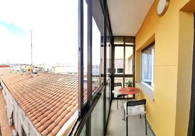 a balcony with a table and chairs on a building at Acojedor piso cerca del metro in Cornellà de Llobregat