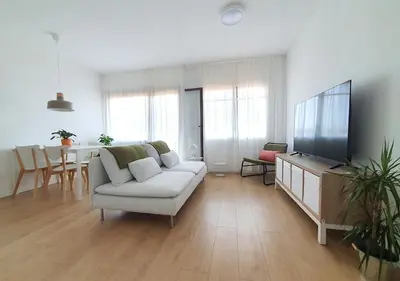 a living room with a white couch and a flat screen tv at Acojedor piso cerca del metro in Cornellà de Llobregat