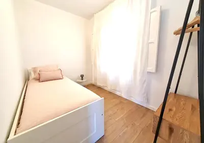 a small bedroom with a bed and a window at Acojedor piso cerca del metro in Cornellà de Llobregat