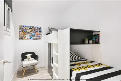 a white bunk bed in a room with a chair at Catalonia Square Terrace & 5 bathrooms 5BD-5BTH in Barcelona