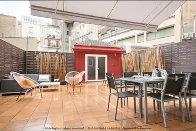 a patio with a table and chairs and a building at Catalonia Square Terrace & 5 bathrooms 5BD-5BTH in Barcelona