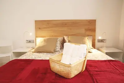 a bedroom with a large bed with a wooden headboard at Hostal Gràcia in Barcelona