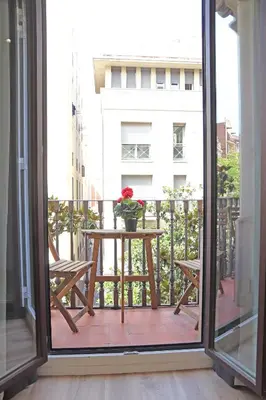a balcony with a table with a flower on it at Hostal Gràcia in Barcelona