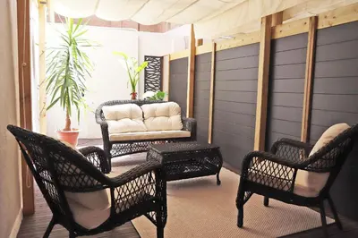 a porch with wicker chairs and a couch at Hostal Gràcia in Barcelona