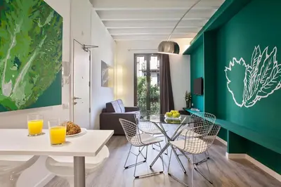 a living room with a green accent wall at Habitat Apartments ADN in Barcelona