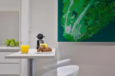 a table with a glass of orange juice and a plate of food at Habitat Apartments ADN in Barcelona
