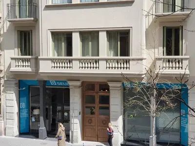 two women walking down a street in front of a building at Casa Balmes in Barcelona