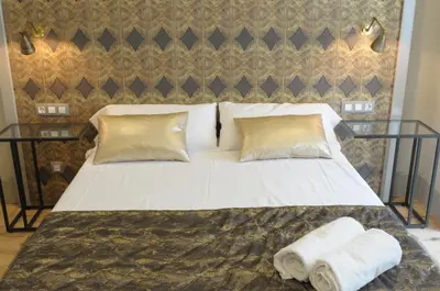 a bed with two pillows and two towels on it at Casa Balmes in Barcelona