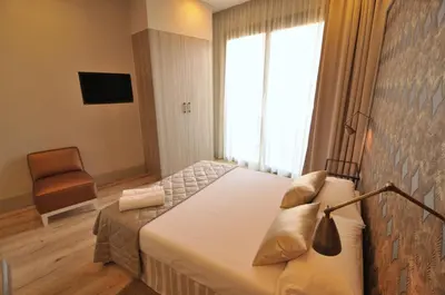 a bedroom with a bed and a window and a chair at Casa Balmes in Barcelona