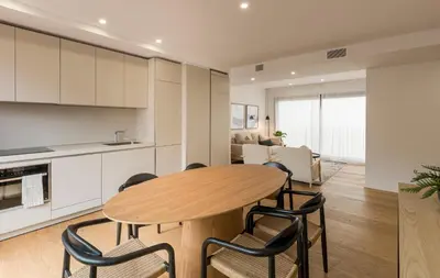 a kitchen and dining room with a wooden table and chairs at CATERINA Editorial in Barcelona