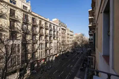 an empty street in front of a large building at Consell Cent Apartment II 3 domitorios Eixample in Barcelona