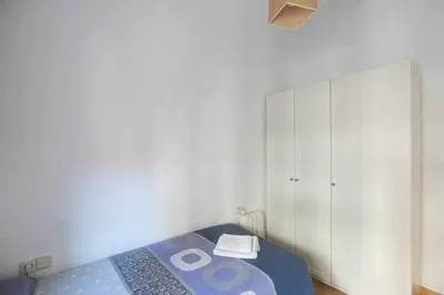 a bedroom with a bed and a white cabinet at Consell Cent Apartment II 3 domitorios Eixample in Barcelona
