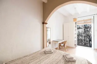 a bedroom with a bed and a desk and a window at Consell Cent Apartment II 3 domitorios Eixample in Barcelona