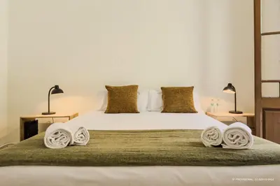 a bedroom with a bed with towels on it at Sagrada Familia 360 in Barcelona