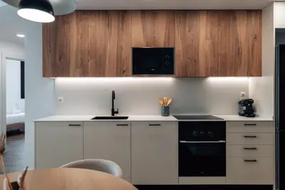 a kitchen with white cabinets and a black stove top oven at CATERINA Liceu in Barcelona