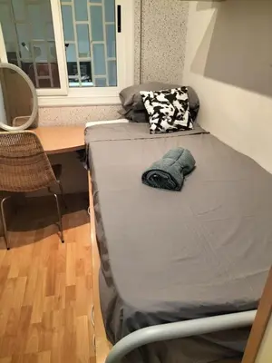 a bed in a room with a desk and a bed sidx sidx sidx at Room in shared appartment close to Camp Nou in Hospitalet de Llobregat