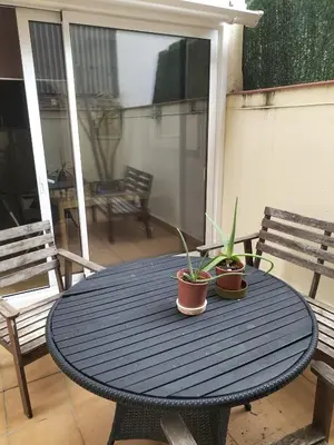 a blue table with two potted plants on a patio at Room in shared appartment close to Camp Nou in Hospitalet de Llobregat