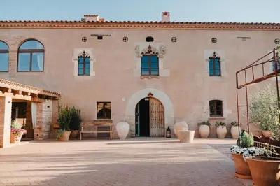a large brick building with a large doorway at Hotel-Masia Can Farrés in El Bruc
