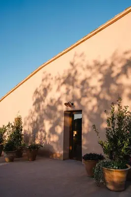 a building with a shadow on the side of it at Hotel-Masia Can Farrés in El Bruc