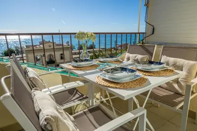 a table on a balcony with a view of the ocean at HomeHolidaysRentals Bluemar-Costa Barcelona in Pineda de Mar