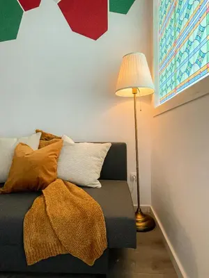 a room with a couch with a lamp and a blanket at Boutique Lepant in Barcelona