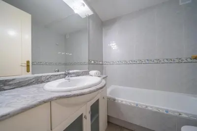 a white bathroom with a sink and a bath tub at HomeHolidaysRentals Noelani- Costa Barcelona in Pineda de Mar