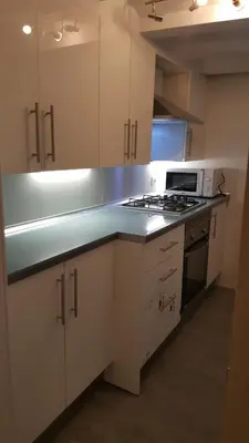 a kitchen with white cabinets and a stove top oven at Apart 2 beds 1 sofabed downtown 31 nigths min Barcelona in Barcelona