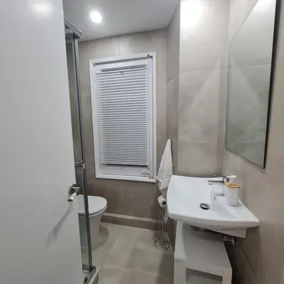 a bathroom with a sink and a toilet and a window at G74 AVENIDA GAUDI nice 4 bedrooms apartment with balcony with views of the Basilica Sagrada Familia in Barcelona