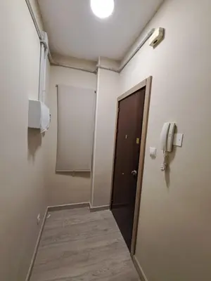 a hallway with a door and a phone on the wall at MERIDIANA sant andreu 4 bedrooms in Barcelona