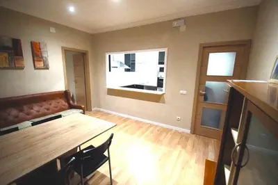 a living room with a wooden table and a window at MERIDIANA CLOT 4 bedrooms 2 bathrooms in Barcelona