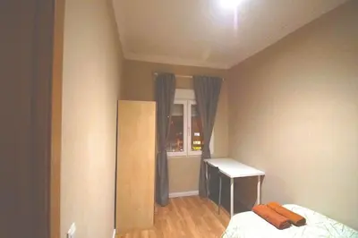 a bedroom with a bed and a desk and a window at MERIDIANA CLOT 4 bedrooms 2 bathrooms in Barcelona