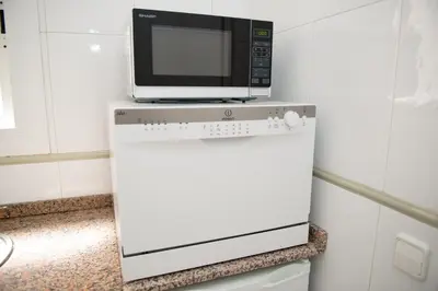 a microwave oven sitting on top of a white appliance at Opening Doors Gràcia in Barcelona