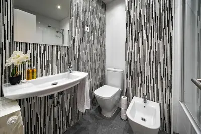 a bathroom with a white toilet and a sink at Habitat Apartments Arenas Parc in Barcelona