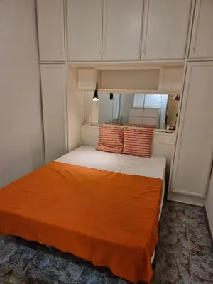 a bedroom with a bed with an orange blanket on it at 2 bedrm BCN down AC WIFI 30 nigths min in Barcelona