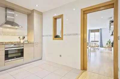 a kitchen with white cabinets and a stove top oven at Ola Living Consell De Cent in Barcelona