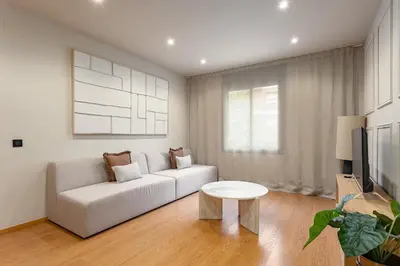 a living room with a white couch and a table at Ola Living Consell De Cent in Barcelona