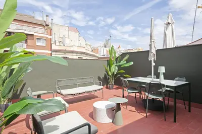 a patio with a table and chairs on a balcony at Ola Living Consell De Cent in Barcelona