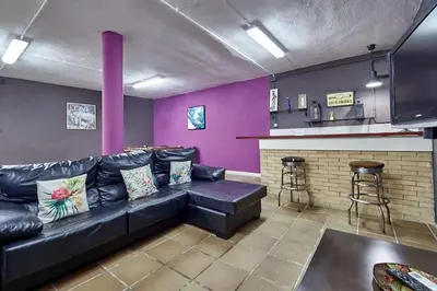 a living room with a black leather couch and a bar at Villa ilusions en Olivella, Sitges, Barcelona in Olivella