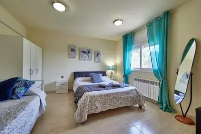 a bedroom with two beds and a mirror at Villa ilusions en Olivella, Sitges, Barcelona in Olivella
