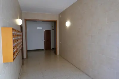 an empty hallway with a door and a wall with wine bottles at Housalia Gracia 2 in Barcelona