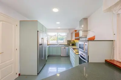 a large kitchen with blue cabinets and a window at Casa Farré next Barcelona Center in Pallejá