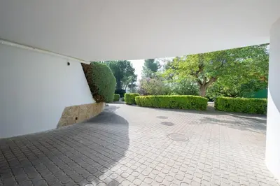 a brick walkway with bushes and a white wall at Casa Farré next Barcelona Center in Pallejá