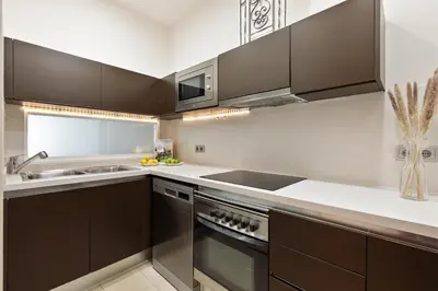 a kitchen with brown cabinets and a sink at Enjoy Apartments Montserrat Boutique Apartment in Eixample in Barcelona