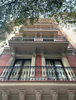 a tall building with a balcony on top of it at Enjoy Apartments Montserrat Boutique Apartment in Eixample in Barcelona