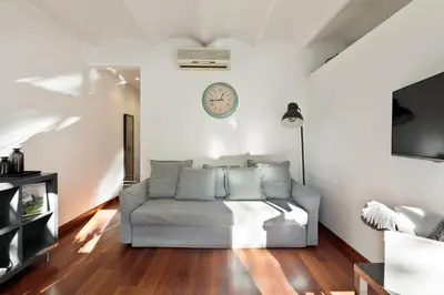 a living room with a couch and a clock on the wall at Enjoy Apartments Urban Retreat Valencia 2 in Barcelona