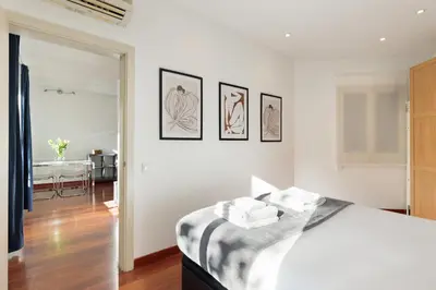 a bedroom with a bed with four pictures on the wall at Enjoy Apartments Urban Retreat Valencia 2 in Barcelona
